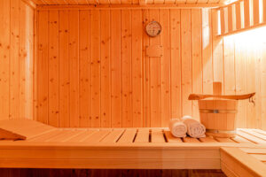 Eine kleine Sauna mit Eimer, Kelle und Handtüchern