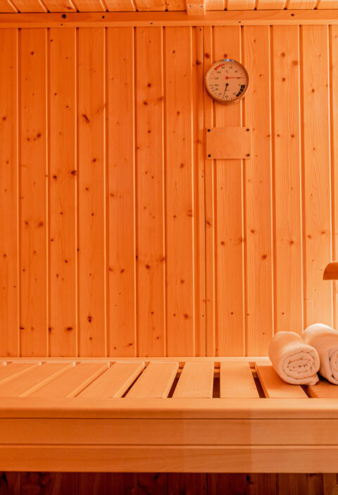 Eine kleine Sauna mit Eimer, Kelle und Handtüchern