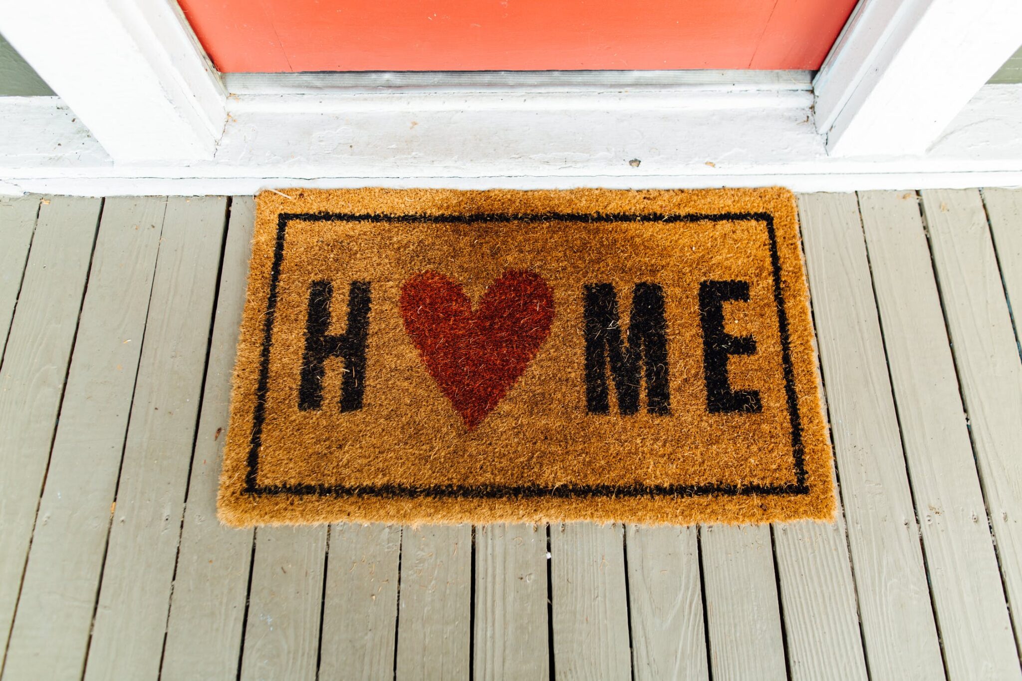 Fußmatte mit der Aufschrift Home vor Eingangstür